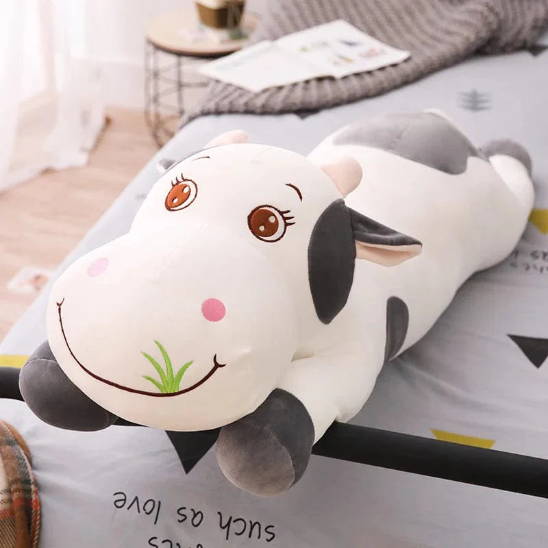 Peluche vache coloré qui broute de l'herbe